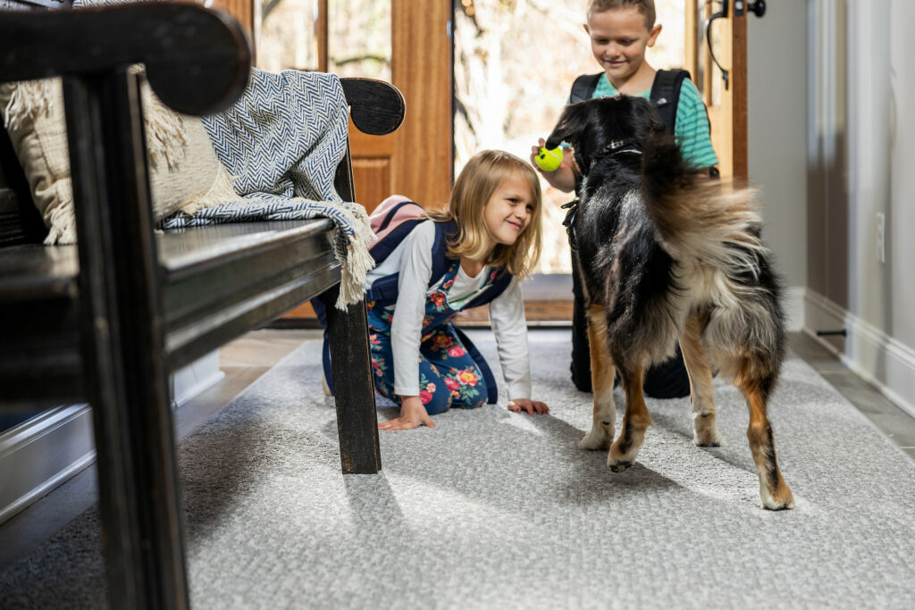 Kids plying with dog on carpet flooring | Carpet Your World